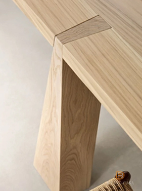 Detail of custom light wood table joint and structure, exemplifying precise woodworking artistry.
